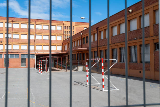 istock Empty schoolyard behind a metal fence during the day 2203270572