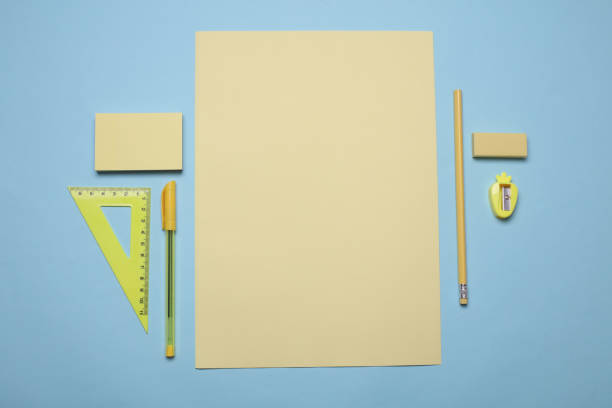 Yellow sheets of paper and school stationery on a blue background. Creative layout