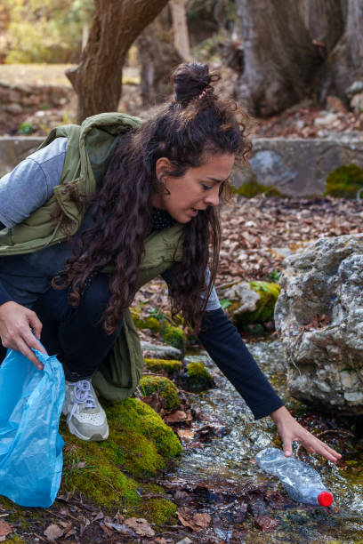 istock Volunteer collecting plastic bottle from stream in forest 2203274004