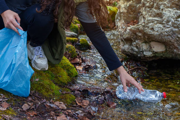 istock Volunteer collecting plastic bottle from stream in the forest 2203274017