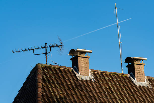istock Rooftops with antennas and chimneys under clear blue sky 2203274299