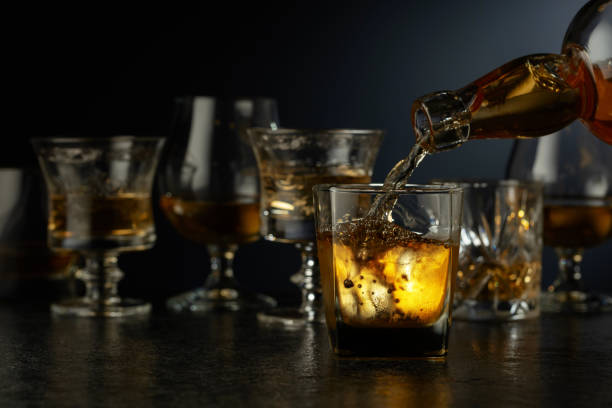 istock Whiskey is poured from a bottle into a glass. 2203276212