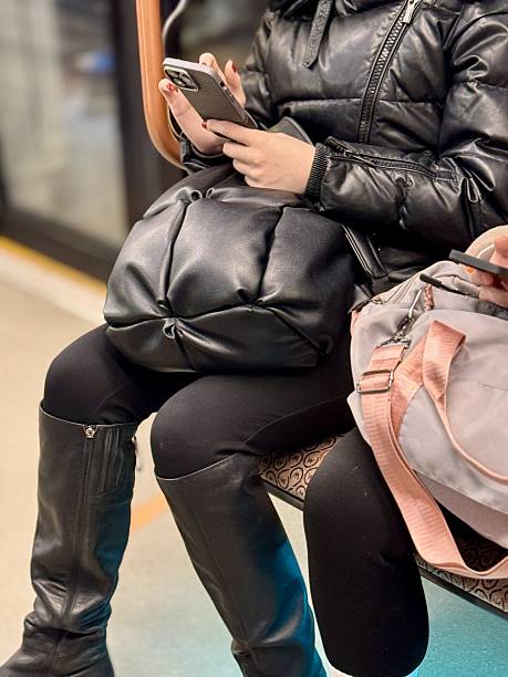 istock Two different individuals were actively engaged with their smartphones while commuting on a busy subway train. People Utilizing Mobile Phones for Communication While Using Public Transport in the City 2203276835