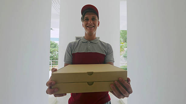 istock Happy young trainee delivers the first order of pizzas. 2203278357
