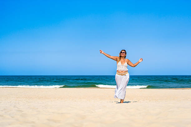 istock Mature woman enjoying vacation at the beach 2203279708