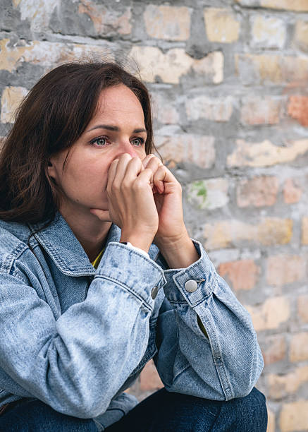 istock Stressed and upset Caucasian woman next to brick wall. 2203280335