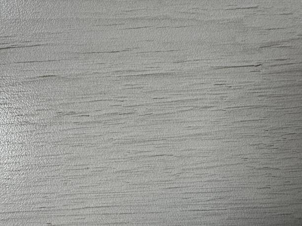 White patterned background from a piece of table with darkening in the lower right corner and lightening in the lower left corner. High quality photo