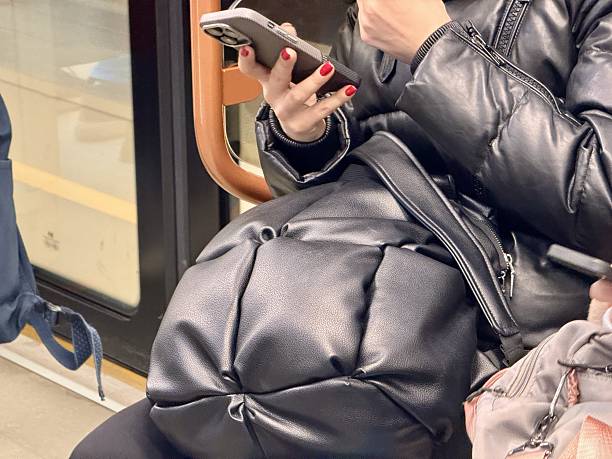 istock One different individual were actively engaged with their smartphones while commuting on busy subway train. People Utilizing Mobile Phones for Communication While Using Public Transport in the City 2203281543