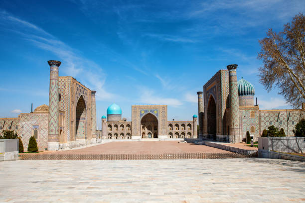 istock Registan Square in Samarkand, Uzbekistan, a historic architectural ensemble featuring three stunning madrasas with intricate mosaic designs, domes, and minarets under a bright blue sky 2203282349