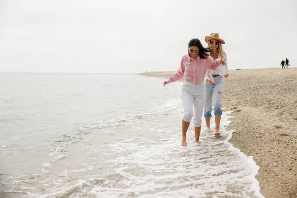 istock Cheerful female friends on vacation at seaside 2203282502