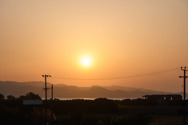 istock Golden sunset casting a warm glow over distant mountains and tranquil waters 2203283757