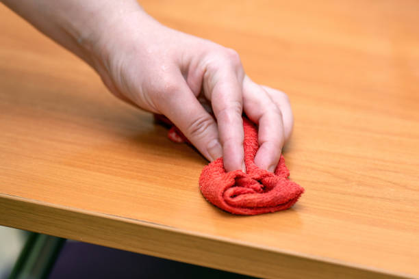 istock hand wipes a table with a red microfiber cloth, showcasing effective cleaning and hygiene practices. The image emphasizes cleanliness and domestic life 2203284613