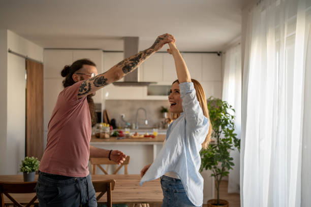 istock Happy couple dancing together in their modern apartment 2203286734