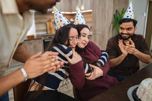 istock Friends hugging and clapping at birthday party 2203288321