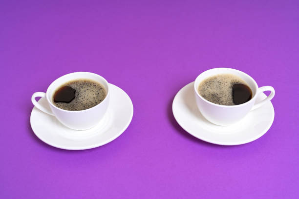 istock Two Cups of Black Coffee on a Purple Background 2203288786