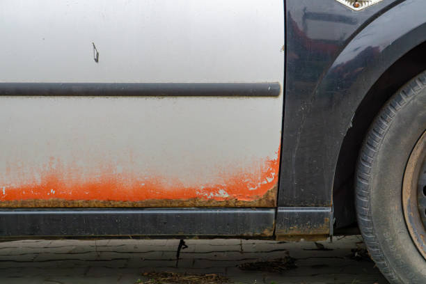 istock multi-colored paints on a car. car sheet metal elements covered with rust. cheap car repair after a collision. botched sheet metal and paint job. abandoned car. 2203289481