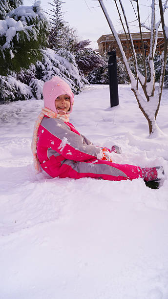 little girl playing with snow inthe park. High quality photo