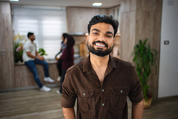 istock Young Indian Man Smiling at Camera in Modern Kitchen 2203291731