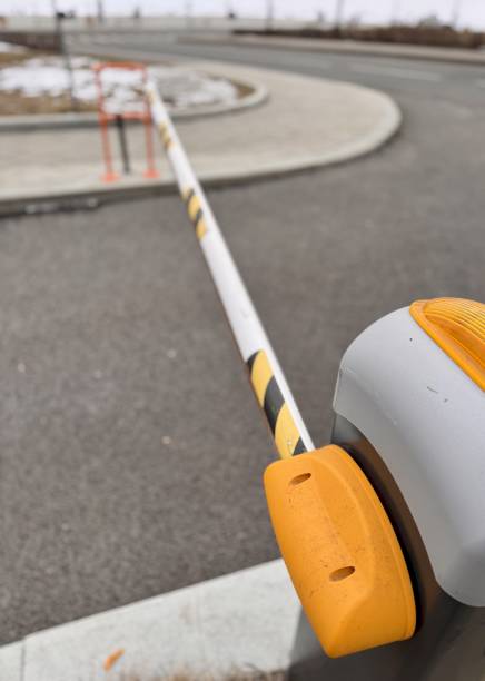 istock Automated security barrier gate currently blocking access to the designated entrance area of a parking lot. A Barrier Gate Positioned at the Entrance of a Parking Facility for Vehicle Access Control 2203294003