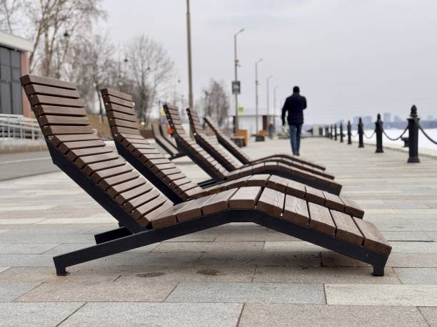 istock Modern loungers thoughtfully arranged by the serene waterfront, ideal for ultimate relaxation and sunbathing enjoyment. Discover Stylish Loungers by Beautiful Waterfront for Ideal Relaxation 2203295415