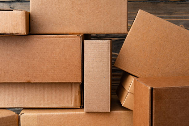 istock Pile of cardboard boxes on wooden background 2203298799