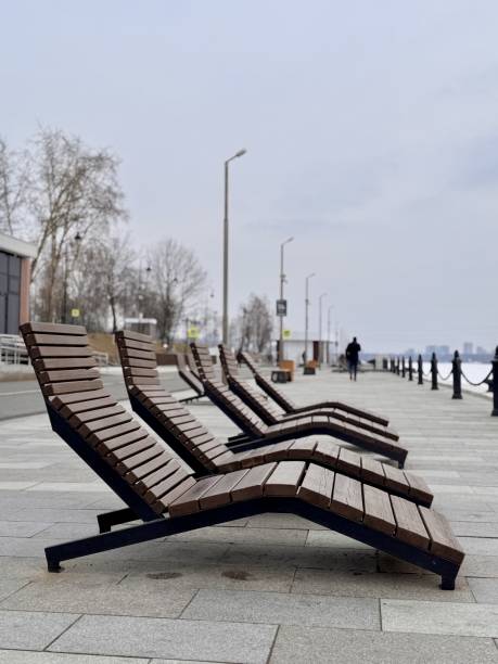 istock Modern loungers thoughtfully arranged by the serene waterfront, ideal for ultimate relaxation and sunbathing enjoyment. Discover Stylish Loungers by Beautiful Waterfront for Ideal Relaxation 2203304423