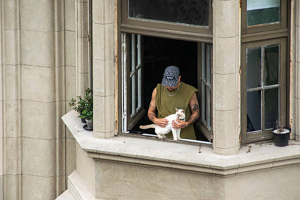 Montevideo, Uruguay: March 1, 2025: Young man with cat at balcony inside palacio salvo palace, the most famous building of montevideo city, uruguay