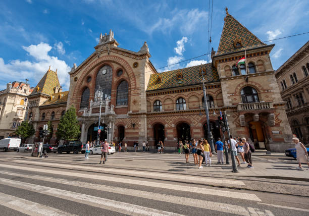 Budapest, Hungary, August 29, 2022. On a beautiful summer day, the entrance facade of the Central Market Hall. People coming and going. Travel destinations.