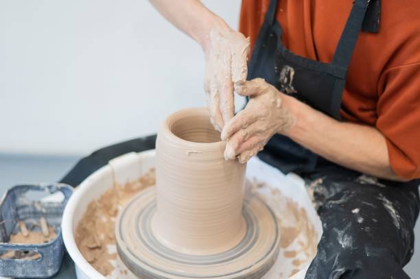 istock Close-up of a potter's hands making a ceramic vase on a potter's wheel. 2203305712