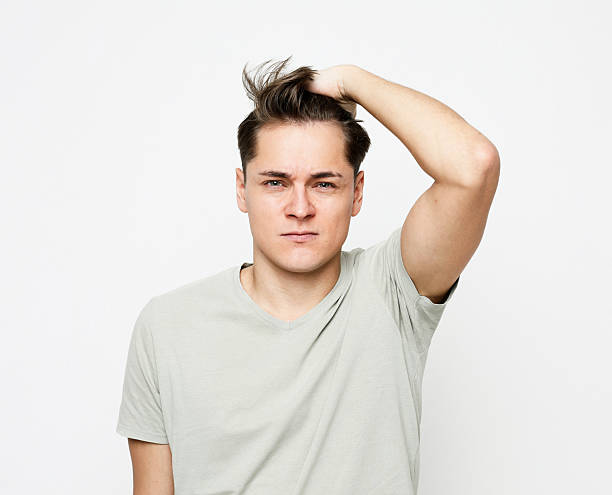 istock a young handsome man touches his head thoughtfully, thinking about something 2203306312