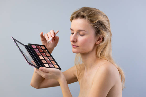 istock A Young Woman Applying Makeup with a Palette: A Modern Take on Beauty and Self-Expression through Artistry in Personal Grooming and Aesthetic Enhancement Techniques 2203306474