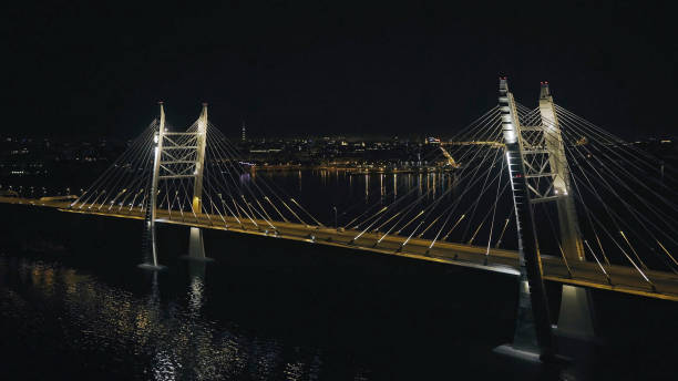 istock Car driving on night cable stayed bridge with modern illumination in city 2203309767