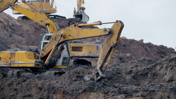 istock Large construction yellow excavators on construction site in quarry 2203310470