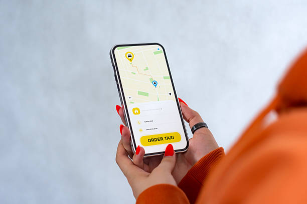 istock Woman holding smartphone with taxi app map screen. 2203311211