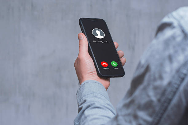 istock A man hand holds a smartphone with an incoming call screen against a concrete wall. 2203312210