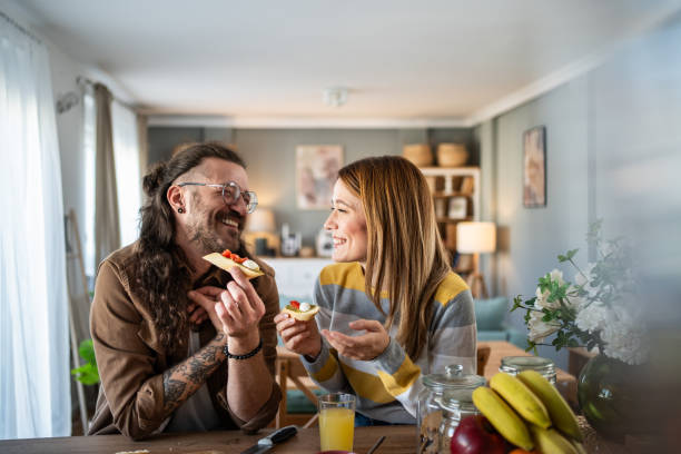 istock Cheerful couple enjoying snacks and conversation at home 2203313816