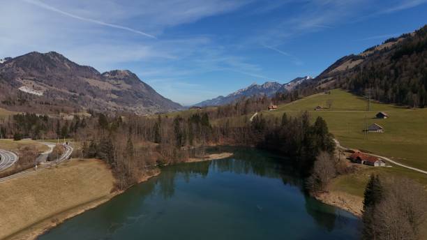 Scenic view of the Bachalpsee mountain lake near First and Grindelwald in the Swiss Alps, with crystal-clear reflections, snow-covered peaks in the background, and a steel-blue sky on a beautiful day in spring or summer