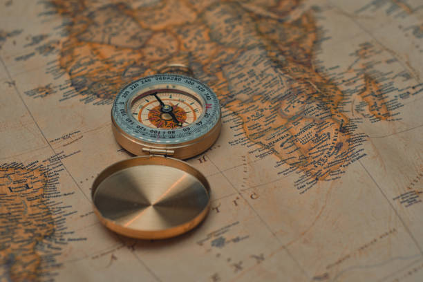 istock Antique brass compass resting on a world map, symbolizing travel and adventure. 2203314557