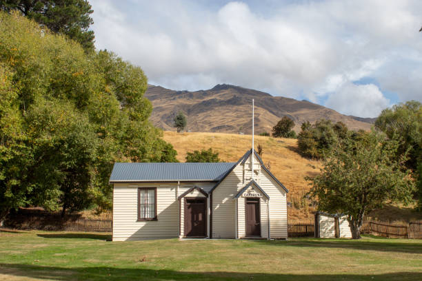 istock Church stands quaintly in a grassy field 2203315517
