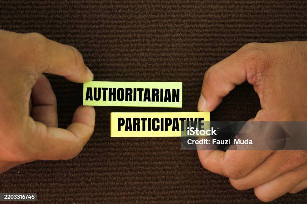 Colored Paper With The Words Authoritarian And Participatory These Theories Refer To Two Management Styles Stock Photo - Download Image Now