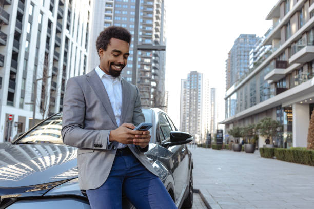 istock Professional man using smartphone outdoors near vehicle in urban setting 2203320003