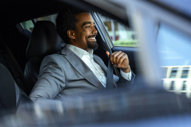 istock Professional businessman fastening seatbelt inside a modern car, emphasizing safety 2203320083
