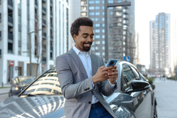 istock Smiling professional man using smartphone in an urban modern cityscape setting 2203320322