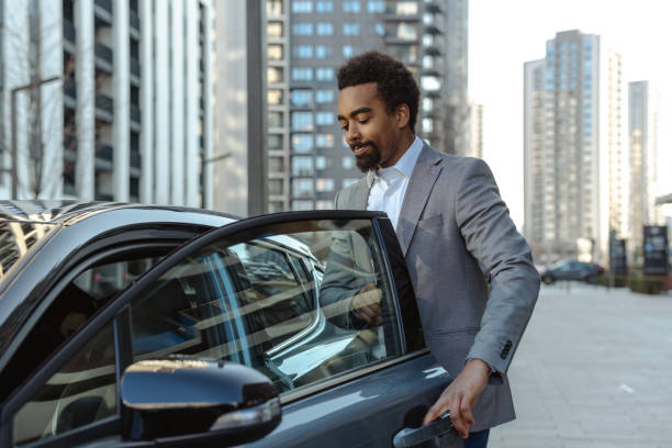 istock Man opening vehicle door in modern urban setting during daytime 2203320905