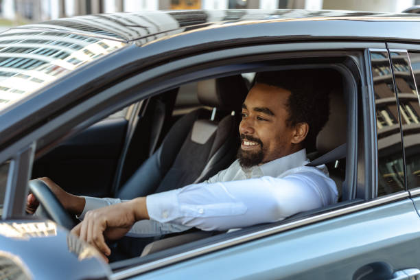 istock Businessman happily driving a car during a weekday commute downtown 2203320938