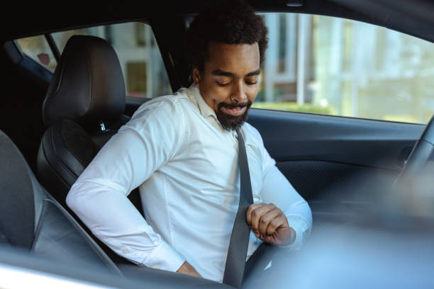 istock Man wearing a white shirt securing seatbelt in modern car interior 2203320951