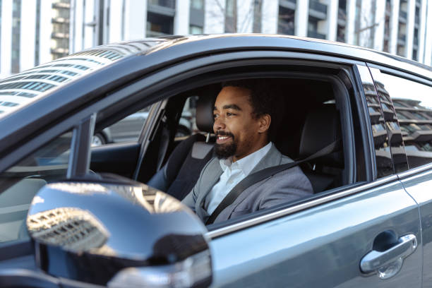 istock Professional young man driving a modern car through an urban city environment 2203321136