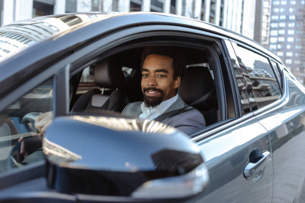istock Smiling professional man driving a sleek car in an urban environment 2203321143