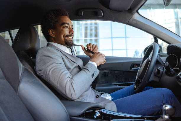 istock Professional man smiling while fastening seatbelt in modern car interior 2203321222