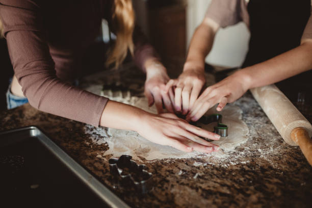 Children using cookie cutters on sugar cookie dough